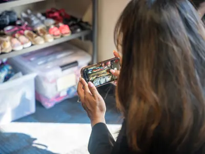 visitor taking photo of children's shoes on shelves