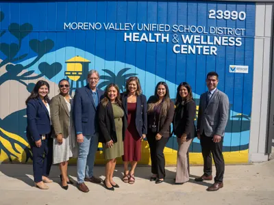 Group photo in front of Moreno Valley Unified School District Wellness Center mural