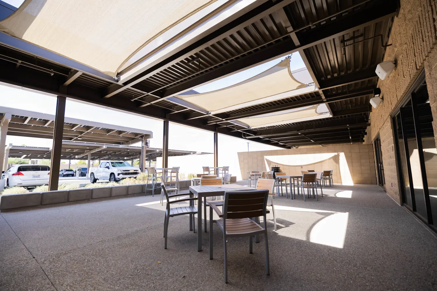 Outdoor seating in shade near parking lot