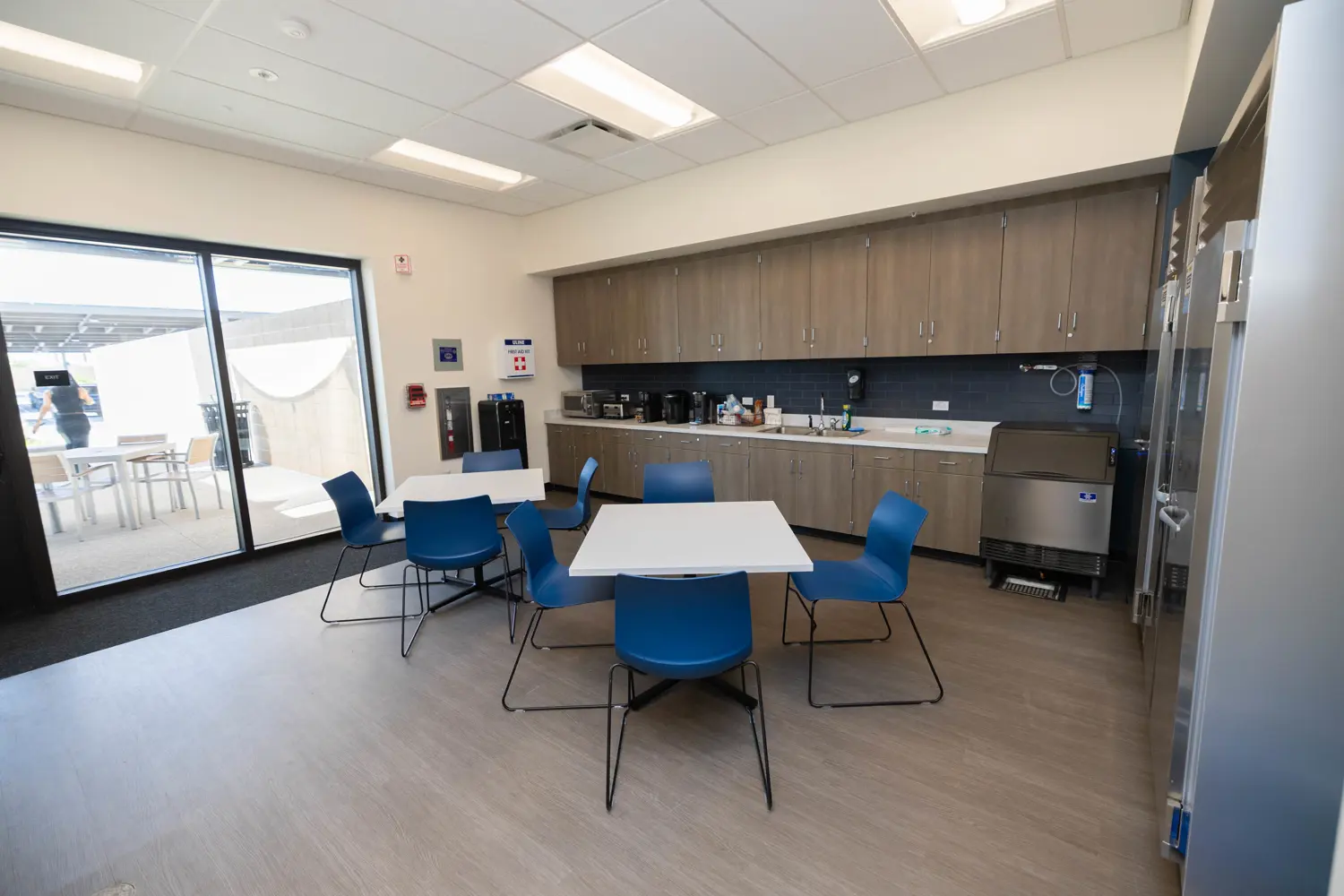 New breakroom with seating and sliding glass door to outdoor seating area
