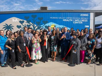 Group applauding the ribbon cutting
