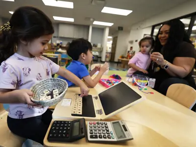 Caregiver engaging with several young children 