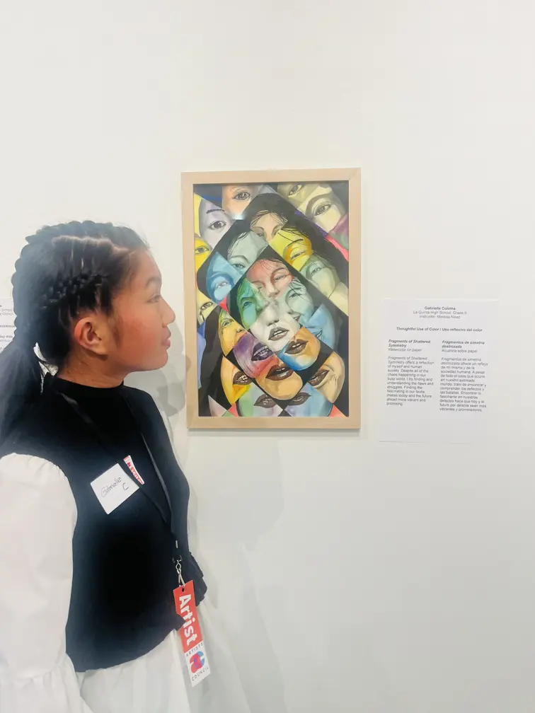 Gabby standing in front of her colorful fragmented art piece displayed inside of the Artist Center Gallery 