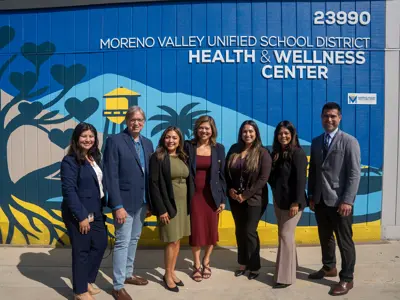 Group photo in front of Moreno Valley Unified School District Wellness Center mural