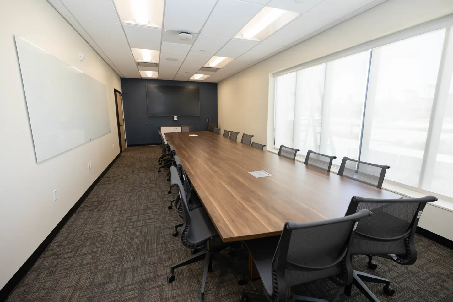 Long narrow meeting room with long table that fills the space perfectly